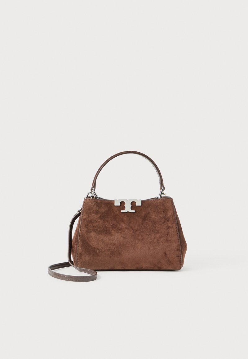 Brun ruskinds håndtaske med en struktureret form, sølvfarvet logo hardware, kort håndtag og en aftagelig skulderrem. Glat tekstur, minimalistisk design.
