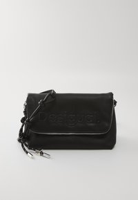 Crna kožna clutch torba s ugraviranim logotipom, zatvaranjem na zip i pletenim remenom za rame s metalnim detaljima. Glatka tekstura i pravokutni oblik.