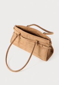 Sac à main en suède beige avec deux poignées, ouverture zippée, corps rectangulaire et coutures le long des côtés. Accents en métal doré.
