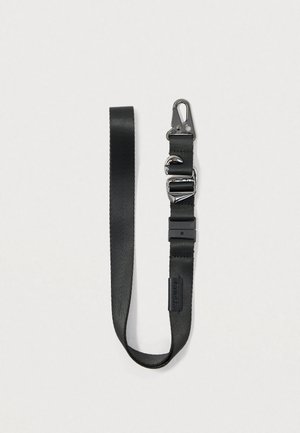 Sangle en nylon noire avec un clip et des accessoires en métal chromé. Ajustable avec une boucle en plastique. Texture lisse, design plat et léger.