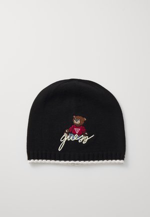 Gorro de malha preto com um urso castanho bordado, vestindo uma camisa vermelha e com detalhes brancos, e a palavra "guess" bordada em estilo cursivo abaixo.