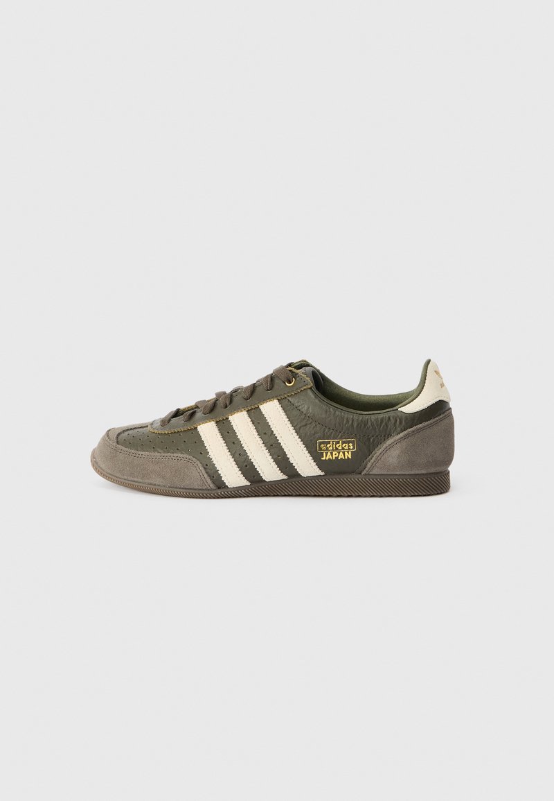 Groene en grijze sneaker met drie witte strepen, textiel leer en suede materiaal, gouden logo accent en platte rubberen zool.