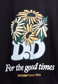 Black fabric featuring a floral design with yellow and white daisies, overlaying the letters "DD" and text "For the good times." Brand: DRDENIM.