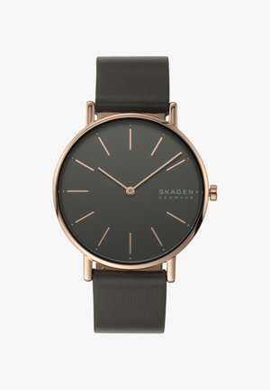 Okrągły zegarek Skagen z ciemnoszarym cyferblatem, różowozłotymi znacznikami i ciemnym skórzanym paskiem. Minimalistyczny design z eleganckimi liniami i bez cyfr.