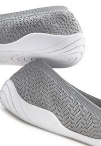 Scarpe slip-on grigie in maglia con tomaia testurizzata, suola in gomma bianca e un delicato motivo a onda sul lato. Design flessibile e leggero.