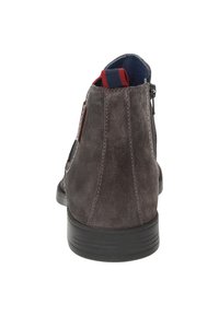 Graue Wildleder-Stiefelette mit einer schwarzen Gummisohle, ausgestattet mit einem rot-blauen gestreiften Kragen und einem schwarzen Reißverschlussdetail an der Seite.