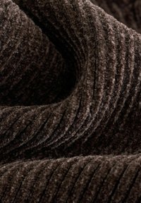 Blød mørkebrun kordfløjl med tykke lodrette ribber og en luksuriøs, tekstureret overflade vist i nærbillede af folder.