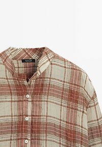 Leinenshirt mit Stehkragen, mit einem Karomuster in Brauntönen und Creme. Knopfverschluss auf der Vorderseite. Weiche Textur.