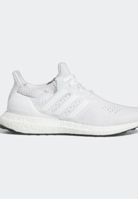 Vita idrottsskor med en mesh-övre, tre vita ränder och en texturerad sula. Har "ultra boost"-logotyp på hälen.