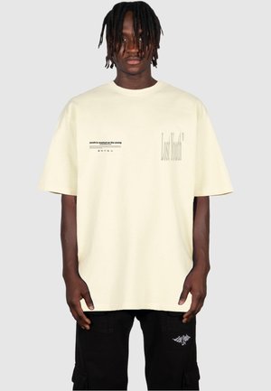Kurzärmliges, hellgelbes Baumwoll-T-Shirt mit Textgrafiken; "Verlorene Jugend" in großer Schrift rechts und einem kleineren Satz links aufgedruckt.