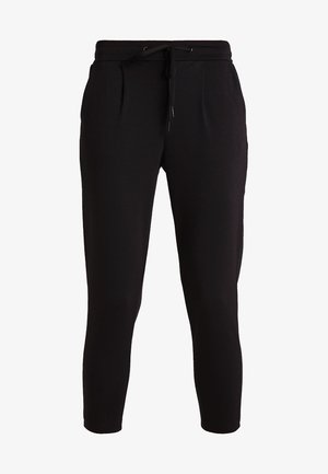 Svarte joggebukser med snøring i midjen, smalere ben og subtile folder foran, laget av myk og komfortabelt stoff.