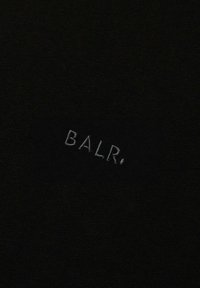 Čierna tkanina s vyšitou „BALR.“ v svetlosivej farbe, s hladkou textúrou a jemným leskom. Jednoduchý, čistý dizajn, bez ďalších vzorov.