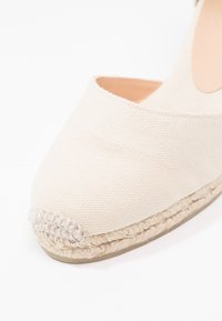 Kanvas espadrille i off-white med rund tå, med en vevd jute såle og subtil tekstur på det øvre materialet.