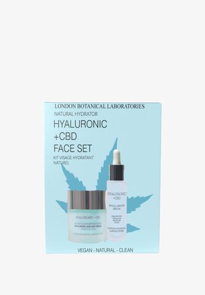 Zestaw do twarzy z kwasem hialuronowym i CBD w niebiesko-srebrnym pudełku, zawierający słoiczek z kremem oraz butelkę z serum, obie z białymi i srebrnymi akcentami.