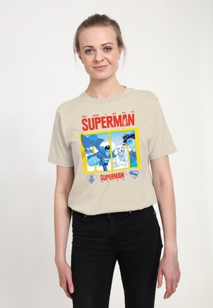 Beige cotton t-shirt featuring a Superman graphic with colorful illustrations and text. The shirt has a crew neckline and short sleeves.