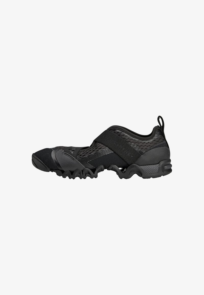 Black athletic shoe featuring a mesh upper, a wide elastic strap across the midfoot, and a wavy rubber sole for traction.