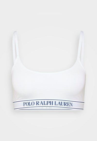 Fehér crop bralette vékony pántokkal. Az alján tengerészkék márkázott szalag található. Sima textúra és alakra szabott kialakítás.