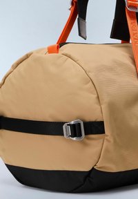 Borsa in nylon tan con fondo nero, di forma rotonda. Presenta manici arancioni e una fibbia argentata. Texture liscia con materiali a contrasto.