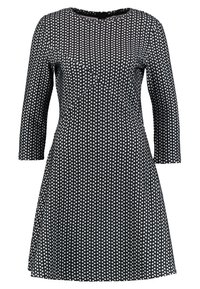 Robe noire avec un corsage ajusté et une jupe évasée. Fabriquée en tissu texturé avec un motif géométrique blanc et des manches trois-quarts.