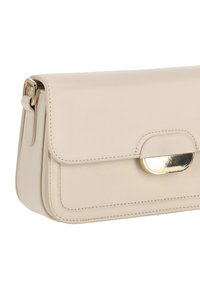 Bolso de cuero beige con diseño estructurado, que presenta un cierre de tono dorado y detalles de costura sutiles en el panel frontal.