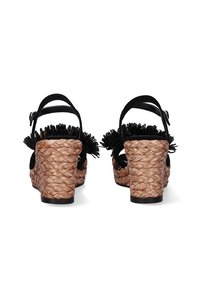 Sandalias negras con tiras y tacón de cuña de yute trenzado. Presentan un adorno floral negro texturizado y una correa en el tobillo ajustable.