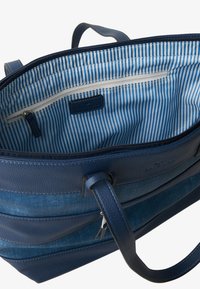 Blauwe getextureerde tote bag met gladde leren accenten, voorzien van een gestreepte voering aan de binnenkant, een ritsvak en dubbele handvatten.