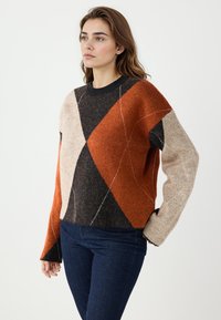 Pull en tricot coloré avec des motifs géométriques en losange orange, noir et beige. Encolure arrondie et manches longues. Texture douce.