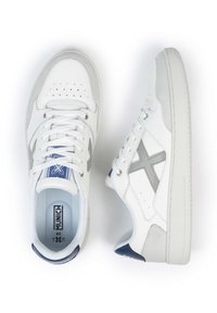 Baskets en cuir blanc avec des accents gris, design à lacets, bout perforé, semelle texturée et logo sur la languette et la semelle intérieure.