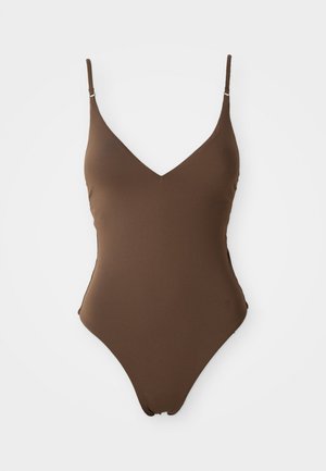 Rudas vientisas maudymosi kostiumas su plonomis reguliuojamomis petnešomis, gilia V formos iškirpte ir glotnia, elastinga tekstūra. Nematyti jokios raštų ar aksesuarų.