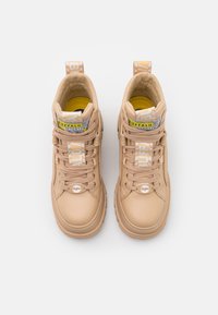 Baskets montantes beiges en cuir texturé, avec des lacets bien marqués, des étiquettes de marque et un col rembourré. Présente une doublure jaune contrastante.