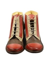 Stivali in pelle marrone con accenti crema e rossi, caratterizzati da una punta arrotondata, una chiusura con lacci e due strisce rosse verticali su ciascun lato.