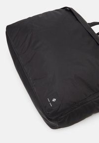 Black nylon backpack with a smooth texture, rectangular shape, and logo patch. Features adjustable straps and a zipper closure.