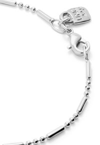 Pulsera de plata que presenta una combinación de cuentas redondas y eslabones tubulares alargados. Incluye un cierre de langosta y una pequeña etiqueta con detalles en relieve.