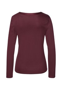 Långärmad skjorta i mörk burgundy, tillverkad av mjukt tyg. Har en rund halsringning och en något rundad nederkant.