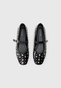 Black leather Mary Jane shoes with a square toe, featuring silver studs evenly spaced across the surface and a slim adjustable strap.