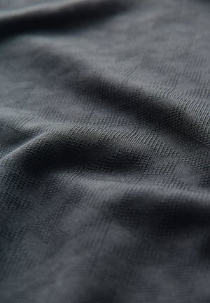 Tela negra texturizada con un sutil patrón geométrico, que muestra una apariencia suave y tejida, con reflejos de luz variables en la superficie.