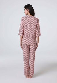 Set di pigiami stampato con un design rosa e motivo geometrico. La parte superiore ha maniche a tre quarti e i pantaloni sono lunghi fino alla caviglia.