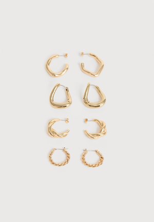 Négy pár aranyszínű karika fülbevaló különböző csavart és szöges mintákkal, függőlegesen elrendezve világos háttéren.