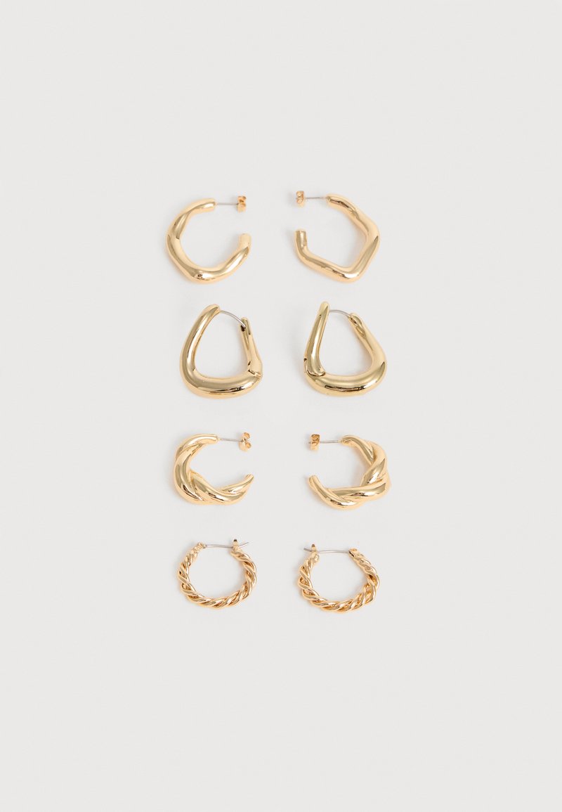 Τέσσερα ζευγάρια χρυσαφί κρίκων σκουλαρικιών με διαφορετικά στριφτά και γωνιώδη σχέδια, τοποθετημένα κάθετα σε ανοιχτό φόντο.