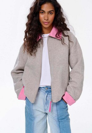 Szara kurtka z mieszanki wełny z różowym kołnierzem i mankietami, z zamkiem błyskawicznym z przodu, kieszeniami bocznymi oraz luźnym krojem.