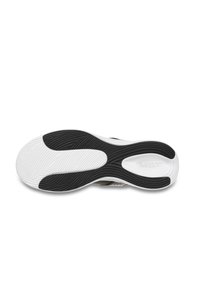 Suola di scarpa in bianco e nero con scanalature e creste curve; presenta un logo. La parte superiore è probabilmente in mesh o tessuto. Design complessivo ergonomico.