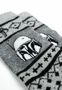 Calze lavorate a maglia grigie con un design di Boba Fett in bianco e nero, caratterizzate da motivi geometrici e accenti neri su tutta la superficie.