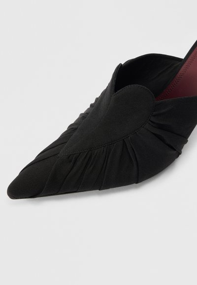 Čierna látková topánka so zašpicatenou špičkou, so zhromaždenou textúrou a v�ýrezom v tvare srdca, s hladkým povrchom a jemným kontrastom farby vo vnútri.