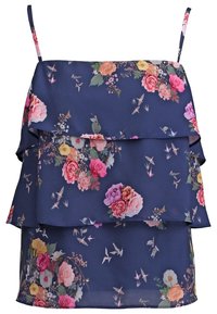 Květinová blůza s námořnickým pozadím, která má vrstvené volány, tenké ramínka a kombinaci barevných květin a malých ptáků.