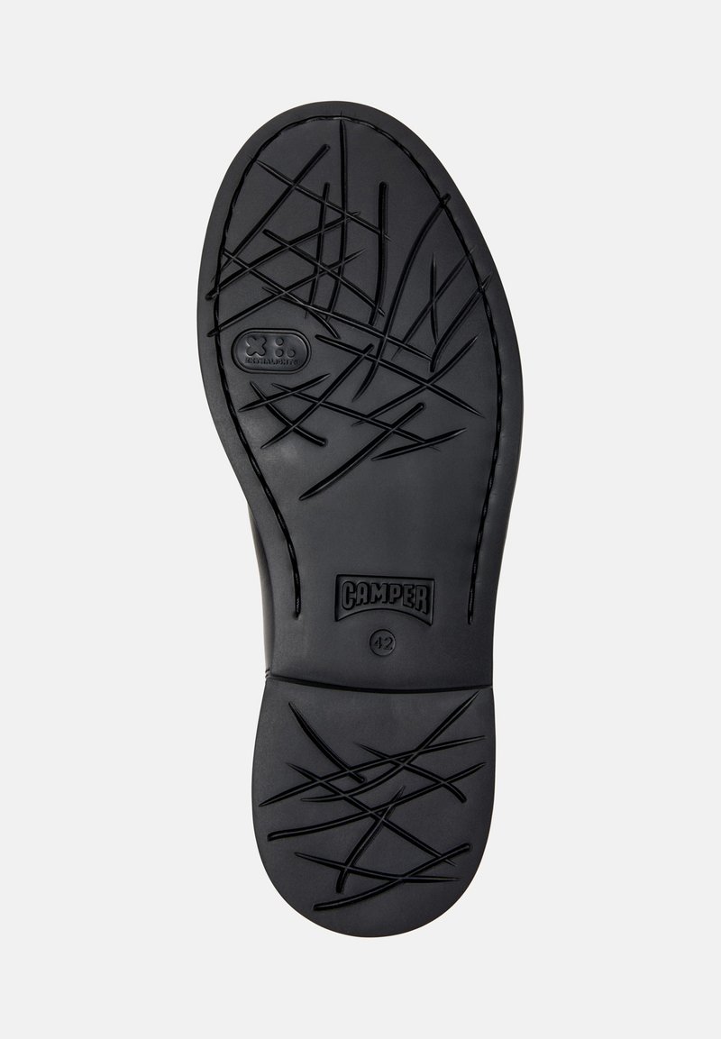 Black rubber shoe sole with abstract crisscross tread pattern, "Camper" brand logo, and size 42 marking on a white background.