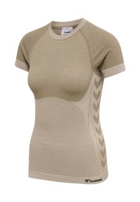 Beżowa sportowa koszulka z krótkim rękawem, z teksturowanym przednim panelem, wzorem strzałek po bokach i logo hummel na dolnym brzegu.
