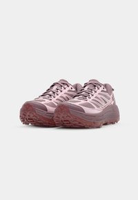 Schnürsport Schuhe in Hellrosa und Mauve, mit einer strukturierten Oberseite, einer robusten Sohle mit tiefen Profilen und reflektierenden Akzenten an der Seite.
