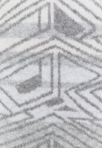 Tela de patrón geométrico en gris y blanco con un acabado suave y texturizado. Presenta ángulos agudos y formas superpuestas que aportan profundidad visual.