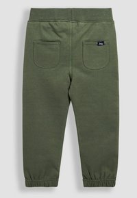 Oliven grønne bomulds joggers med elastisk talje og manchetter, med to syede baglommer og minimal brandingdetalje.