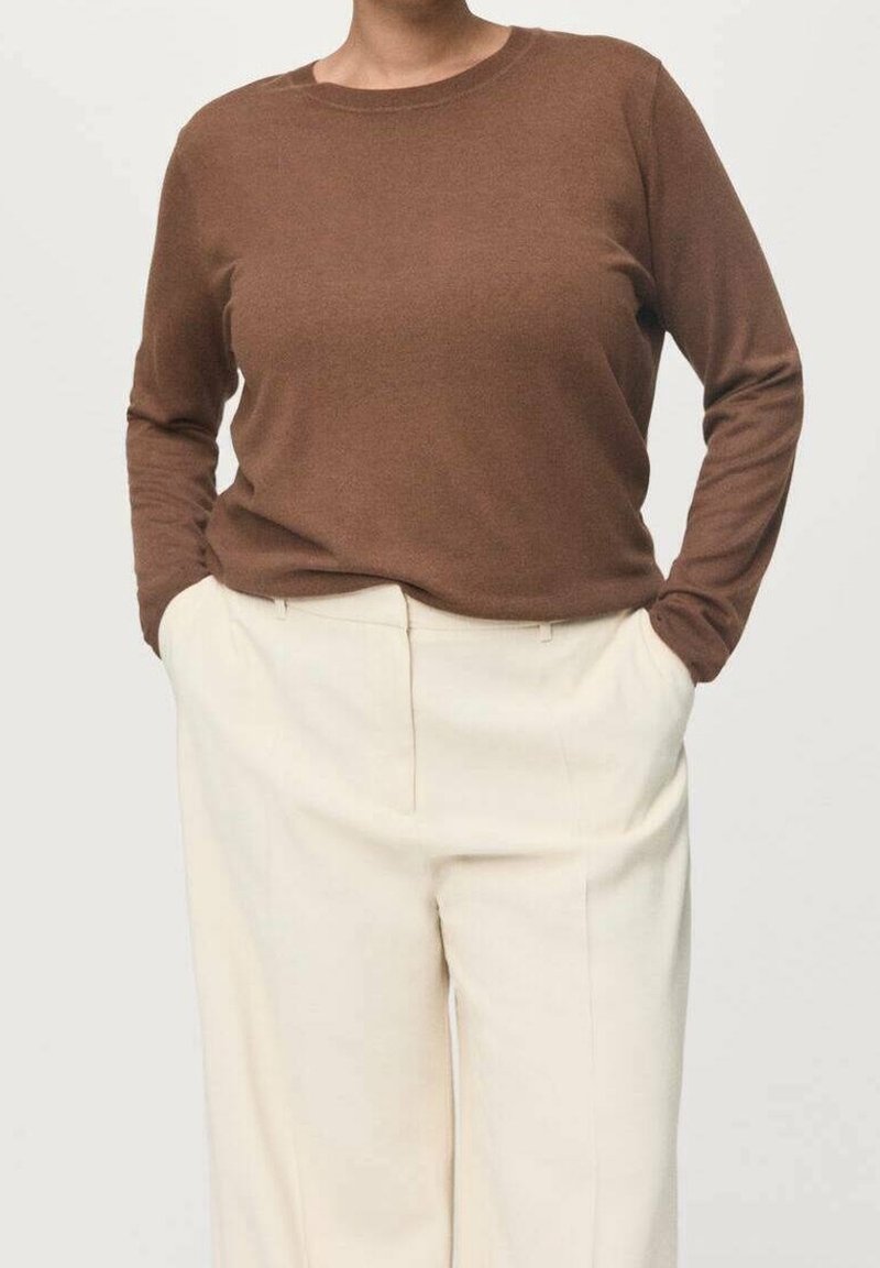 Haut marron à manches longues en tissu doux, associé à un pantalon blanc taille haute, présentant une coupe décontractée et des détails de design minimalistes.